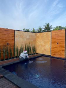 a swimming pool with a water feature in a backyard at Villa Ole in Ubud