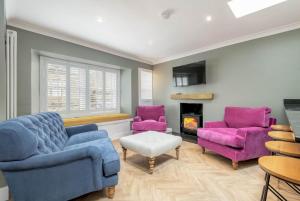 a living room with two purple chairs and a fireplace at The Golf Cottage - 30 Seconds to The Old Course in St Andrews
