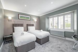 1 dormitorio con 2 camas y ventana en The Golf Cottage - 30 Seconds to The Old Course en St Andrews