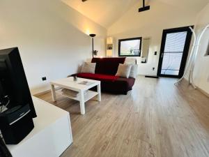 a living room with a couch and a table at Villa Louméa - Le Chalet avec jacuzzi in Friesenheim