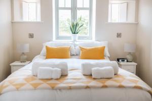 a white bedroom with a large bed with two windows at The Old Granary in Barnetby le Wold