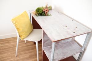 un tavolo con un cuscino giallo e una sedia di Borboleta Guest House a Figueira de Castelo Rodrigo