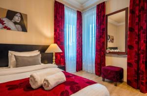 1 dormitorio con 1 cama y cortinas rojas en Iliani Hotel, en Tiflis