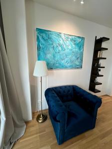 een blauwe bank in een kamer met een schilderij aan de muur bij The View 15.06 Quartier Belvedere in Wenen