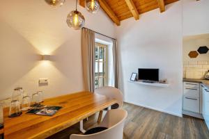 kuchnia i jadalnia z drewnianym stołem i krzesłami w obiekcie Mountain Residence Kasern Nr 4 w mieście Predoi +15 zdjęć