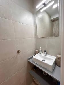 ein weißes Badezimmer mit einem Waschbecken und einem Spiegel in der Unterkunft Villajoyosa Family Apartment in Villajoyosa