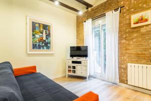 sala de estar con sofá y TV en Apartamento Ruzafa Centro II, en Valencia