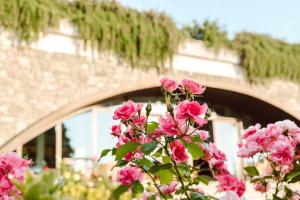 un ramo de flores rosas delante de un puente en Merumalia Wine Resort, en Frascati