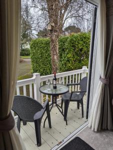 a patio with a table and chairs on a porch at Ambleside SHOREFIELD Holiday Park in Quiet cul de sac ENTERTAINMENT AND LEISURE PASSES INCLUDED in Milford on Sea