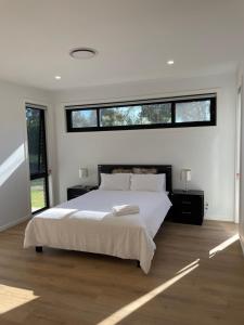 sypialnia z dużym białym łóżkiem i oknem w obiekcie Star in Macquarie w mieście Weetangerra