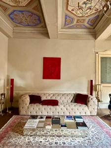 a living room with a white couch and a red painting at Domus Tua in Modena