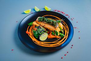 a black plate of food with carrots and pasta at Hotel Jelgava in Jelgava