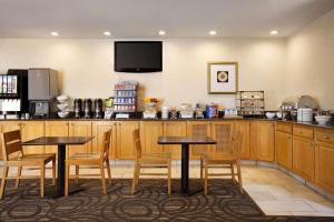 a kitchen with two tables and chairs and a television at Country Inn & Suites by Radisson, Lexington, VA in Lexington