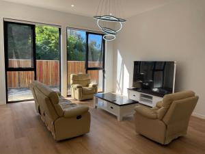 sala de estar con 2 sillas y TV de pantalla plana en Star in Macquarie en Weetangerra