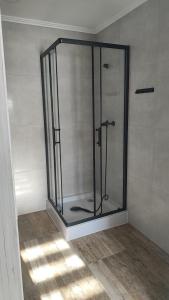 a glass shower in a room with a wall at U Bieńka in Biały Dunajec