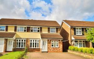 a house with a driveway in front of it at Addlestone Stylish Spacious Three Bedroom House in Addlestone
