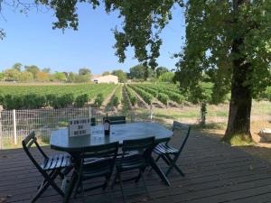 uma mesa de piquenique com um cartaz ao lado de uma vinha em Maison vue sur vignes Piscine chauffée Privée 6per BELLEVUE em Cussac-Fort-Medoc