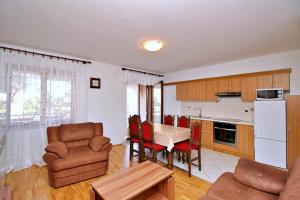 a kitchen and living room with a table and chairs at Apartment Dunato I in Šilo
