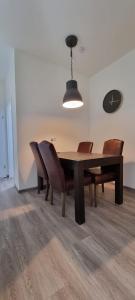 Sechsbettzimmer "Blau" in zentraler Lage في بريمين: غرفة طعام مع طاولة وكراسي خشبية