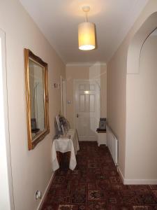 a hallway with a table and a mirror in a room at Glenavon Homestay in Oban