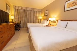 um quarto de hotel com duas camas e uma secretária em Radisson Hotel Panama Canal na Cidade do Panamá