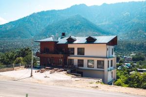 a building on the side of a road with a mountain at Clover Inn by Offlimit Homes in Shamshi