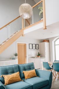 a living room with a blue couch and a staircase at The Old Granary in Barnetby le Wold
