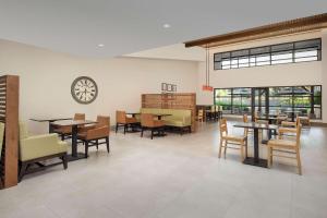 a waiting room with tables and chairs and a clock at Country Inn & Suites by Radisson, Seattle-Tacoma International Airport, WA in SeaTac