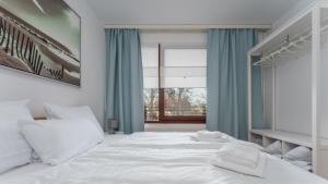 a bedroom with a white bed and a window at Ferienwohnung Kellenhusen Ostsee in Kellenhusen