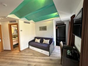 a living room with a couch and a green ceiling at Antídoto Rooms Zocodover in Toledo