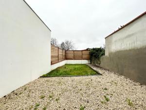a courtyard of a house with a fence at L'IMPÉRIAL - Jardin & Parking in Mont-de-Marsan