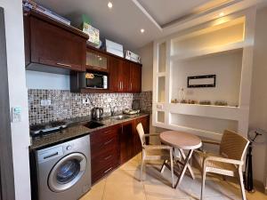 cocina con lavadora, mesa y sillas en Studio with private garden and pool view in Sharm Hills, en Sharm El Sheikh