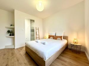 a bedroom with a large bed with white sheets at L'IMPÉRIAL - Jardin & Parking in Mont-de-Marsan