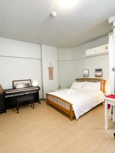 a bedroom with a bed and a piano at Tower Resident in the Heart of Bangkok Shopping Center in Makkasan