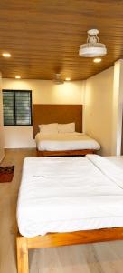 two twin beds in a room with avertisementatronatronatronstrationstrationettlementettlement at Baga Sea Link in Baga