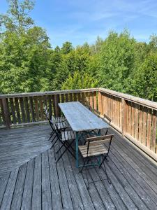 a picnic table and two chairs on a deck at Liljenborg in Jämshög