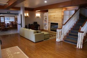 sala de estar con sofá y escalera en Country Inn & Suites by Radisson, Lansing, MI, en Lansing