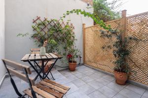 a patio with a table and a bench and plants at Phaedrus Living: The Nine Muses Erato in Athens