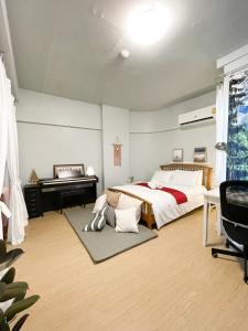 Tower Resident in the Heart of Bangkok Shopping Center في Makkasan: غرفة نوم بسرير ومكتب وبيانو