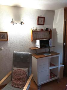 Zimmer mit Mikrowelle und Schreibtisch mit Stuhl in der Unterkunft EDL11 - Studio 4 Pers centre des Carroz in Les Carroz d'Araches