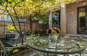 a glass table with a vase of flowers on it at Iliani Hotel in Tbilisi City