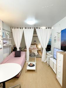 a bedroom with a bed and a desk and a tv at Tower Resident in the Heart of Bangkok Shopping Center in Makkasan