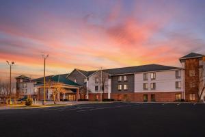 ein Gebäude auf einem Parkplatz mit Sonnenuntergang in der Unterkunft Quality Inn in Warrensburg