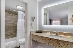 a bathroom with a sink and a toilet and a mirror at Quality Inn & Suites Orlando East - UCF Area in Orlando +49 photos