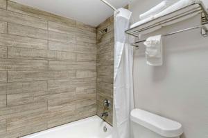 a bathroom with a white toilet and a shower at Quality Inn & Suites Orlando East - UCF Area in Orlando