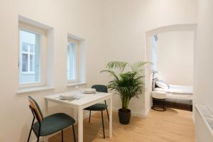 um quarto com uma mesa e cadeiras e um quarto em The Bank Poznan Apartments em Poznań