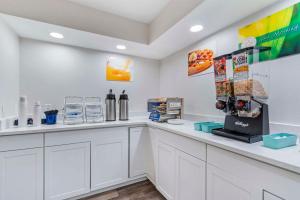 a kitchen with white cabinets and a counter at Quality Inn & Suites Orlando East - UCF Area in Orlando