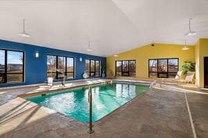 a large swimming pool in a room with windows at Quality Inn in Warrensburg