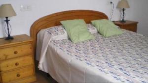 - un lit avec 2 oreillers verts dans l'établissement Casa 2-h, à Sant Francesc Xavier