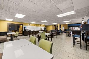 une salle à manger avec des tables et des chaises ainsi qu'une cafétéria dans l'établissement Quality Inn, à Warrensburg